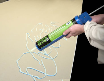 Applying Green Glue on panel on the Natural Handyman home repair and do it yourself website