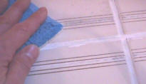 Using abrasive sponge to remove excess grout colorant